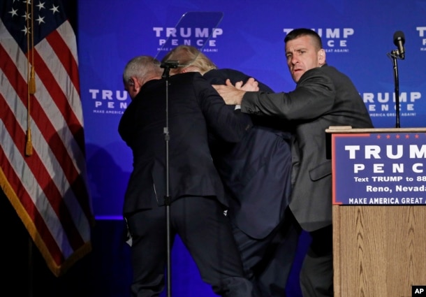 Secret Service agents rush Republican presidential candidate Donald Trump off the stage at a campaign rally in Reno, Nev., Nov. 5, 2016.
