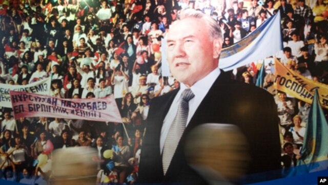 Parliamentary members walk past a poster of Kazakh President Nursultan Nazarbayev' after his annual state of the nation address, Astana, 2008 (FILE).