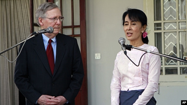 U.S. Senator Mitch McConnell, left, listens to Burmese pro-democracy leader Aung San Suu Kyi talk to journalists during a press conference after their meeting at her home in Rangoon, January 16, 2012.