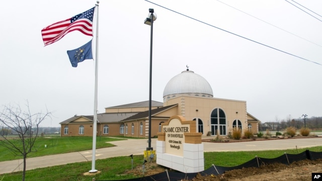 FILE - An American flag and the Indiana state flag fly in front of the Islamic Center of Evansville in Newburgh, Indiana, Nov. 30, 2015.