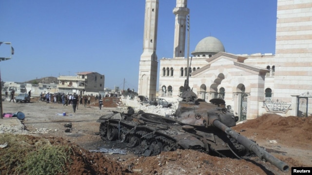 A burned tank belonging to government forces is seen in Azzaz, Aleppo province, Syria July 19, 2012.