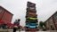 People look at a sculpture made of 13 scrapped cars created by Gu Yuan and Sun Yeli at a cultural industrial park in Wuhan, Hubei province, China.