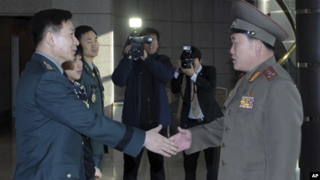 South Korean Colonel Moon Sang-gyun (l) shakes hands with his North Korean counterpart Ri Son-kwon before their talks at the south side of the truce village of Panmunjom in Paju, north of Seoul, February 9, 2011