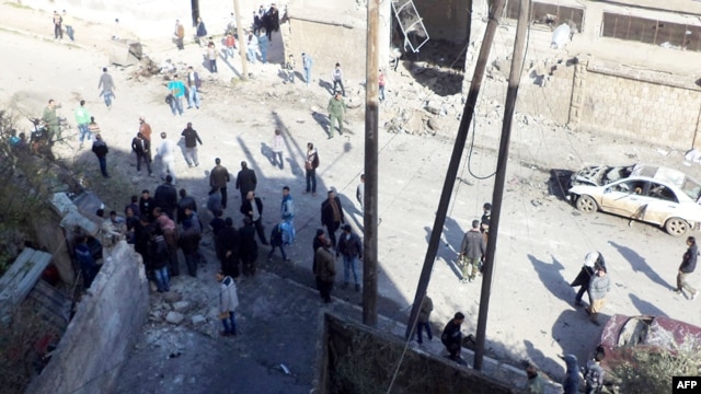 A handout picture released by the Syrian Arab News Agency shows Syrians inspecting the site of a car bomb blast in the northwestern city of Idlib, January 16, 2013.