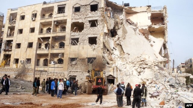 Syrians gather next to the scene of an explosion in Aleppo, January 18, 2013.