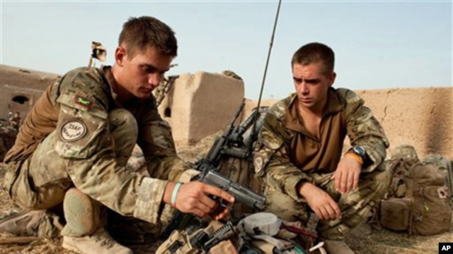 In this undated handout photo from Britain's Ministry of Defense made available on July, 31, 2010, Lt. Olly Field, left and Bombadier Matthew Nichols check their kit, after moving into a compound outside Sayedebad, central Helmand, Afghanistan.