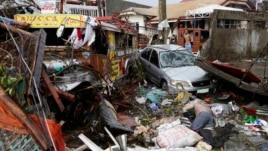 Xe cộ và tử thi nằm giữa đống đổ nát sau bão Haiyan trong thành phố Tacloban, tỉnh Leyte, miền trung Philippines.
