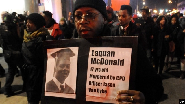 A protester holds a sign as people rally in memory of 17-year-old Laquan McDonald, who was shot 16 times by Chicago Police Department Officer Jason Van Dyke, in Chicago, Nov. 24, 2015.