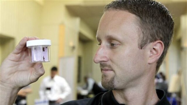 Entomologist Jeff White holds a container of live bed bugs at the North American Bed Bug Summit in Rosemont, Illinois, on September 21