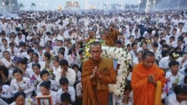 Thousands of mourners pray at the gates of the Royal Palace after the coffin of former king Norodom Sihanouk entered in Phnom Penh October 17, 2012. Tens of thousands poured into Cambodia's capital to witness the procession on Wednesday.