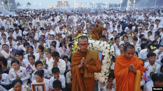 Thousands of mourners pray at the gates of the Royal Palace after the coffin of former king Norodom Sihanouk entered in Phnom Penh October 17, 2012. Tens of thousands poured into Cambodia's capital to witness the procession on Wednesday.