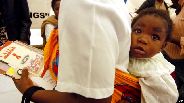 FILE - A mother carries a child on her back as she visits an exhibition on HIV/AIDS in Gaborone, Botswana. The country has reached a viral suppression rate of 96 percent among its infected citizens.