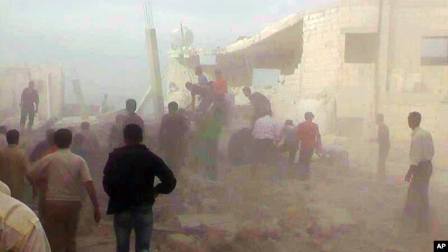 Cư dân Syria giải cứu người bị kẹt dưới đống đổ nát của một tòa nhà bị phá hủy bởi một vụ không kích của lực lượng Syria tại thị trấn Kfar Nebel, trong tỉnh Idlib, ngày 17/10/2012