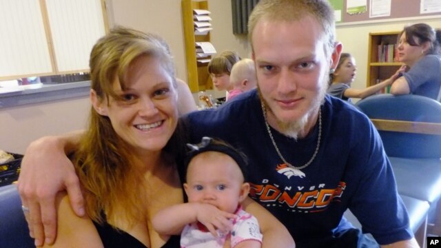 New parents Garrett Goudeseune, 25, Laura Fritz, 27, left, with their daughter Adalade Goudeseune, are at the Jefferson Action Center, an assistance center in the Denver. The couple has struggled to find work, now relying on government assistance to cover food and $650 rent for their family, July 16, 2012.