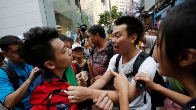 Một sinh viên biểu tình ủng hộ dân chủ (trái) bị xô đẩy bởi người dân địa phương tìm cách dời hàng rào phong tỏa các con đường ở Causeway Bay, Hong Kong 3/10/14