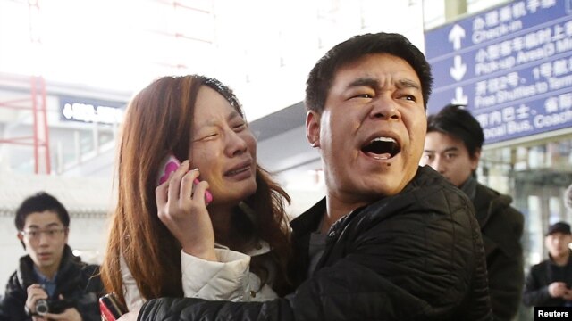 Thân nhân của 1 hành khách trên chuyến bay MH370 của Malaysia Airlines khóc khi đang nói chuyện điện thoại tại sân bay quốc tế Bắc Kinh, Trung Quốc, 8/3/2014