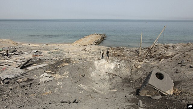 Palestinian boys survey the damage after an Israeli air strike in a resort in Gaza city, April 16, 2011
