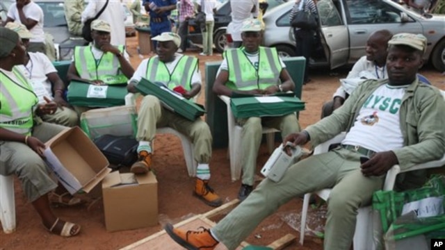 Electoral officials wait for ballot material at the distribution center  in Ibadan, Nigeria, Saturday, April 2, 2011