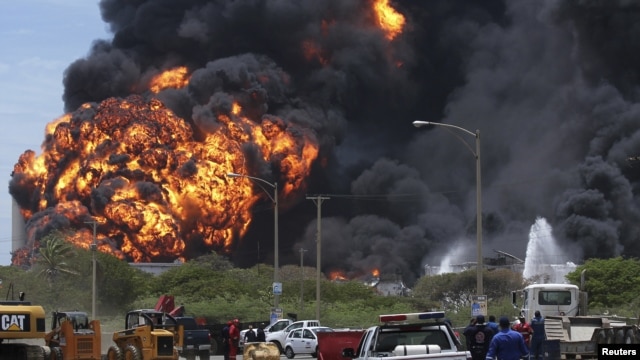 A fire burned for a third day in two fuel storage tanks at Venezuela's biggest refinery, August 27, 2012.