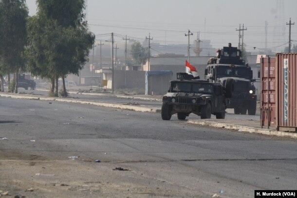 Army vehicles race back from the battle front deeper in the city in Gogjali, Mosul, Iraq, Nov. 7, 2016.