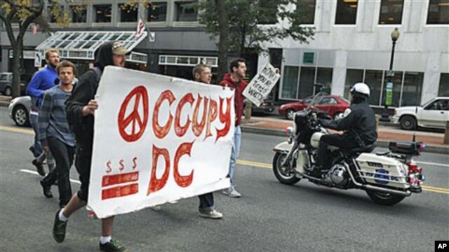 A police on a motorcycle passes a group of Occupy DC protesters as they march from McPherson Square to a Bank of America on K Street in Washington, October 20, 2011.