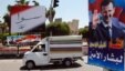 FILE - A vehicle drives past campaign posters for a presidential election in Damascus, Syria, May 12, 2014. Opposition politicians argue upcoming parliamentary elections are an effort by Assad to project a political legitimacy he doesn’t have.