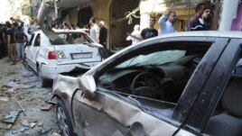 Wananchi wa Syria wakiangalia magari yaliolipuliwa na mabomu.