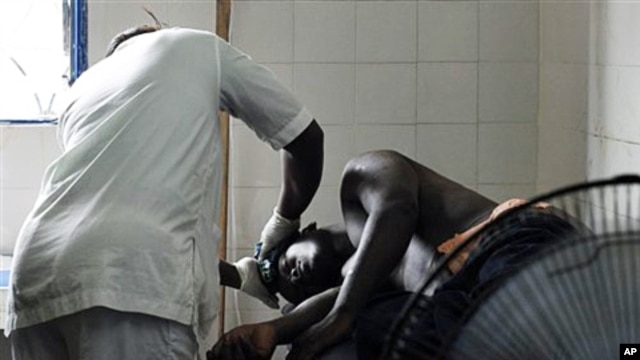 A man receiving treatment at a health clinic after being shot in the hip by security forces loyal to Laurent Gbagbo in the Anyama suburb of Abidjan, March 12, 2011