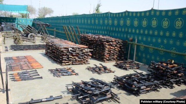 FILE - An undated photo shows weapons, ammunition, explosives and communication equipment found by Pakistani troops during a reaid on suspected militant hidouts in North Waziristan.