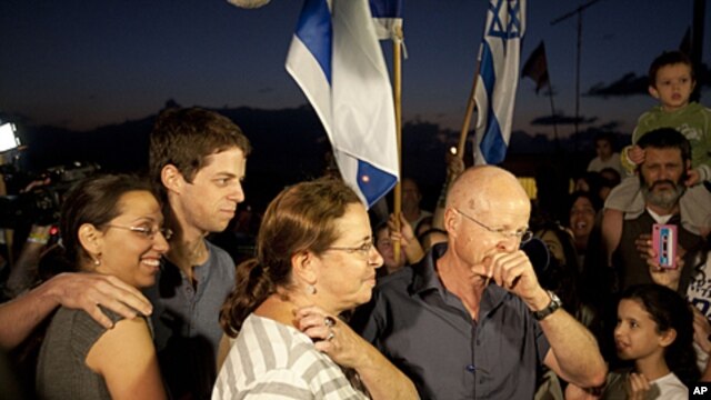 Noam and Aviv Schalit, right, Yoel Schalit and Yaara Winkler, parents and brother of captured Israeli soldier Gilad Schalit are welcomed by family and friends to their home in Mitzpe Hila, northern Israel, October 12, 2011.