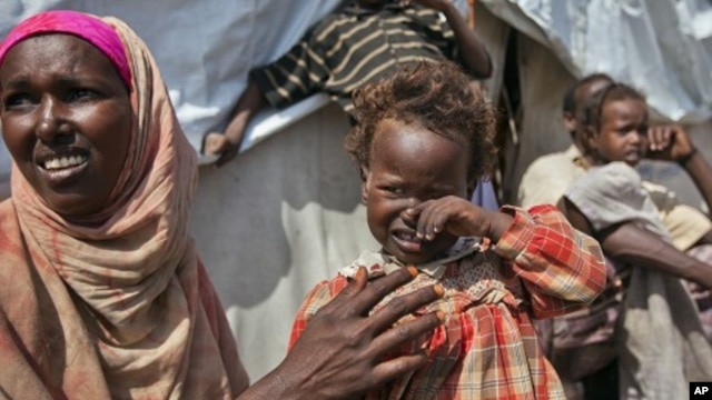 Nasteho Hassan Mohyadin, 3, and her mother Farhid Ali Mohamed sit outside their small makeshift tent in a camp for those displaced by last year's famine or by conflict, in Mogadishu, Somalia, Jan. 19, 2012.
