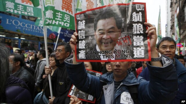 Protesters hold a picture of Hong Kong's Chief Executive Leung Chun-ying on New Year's Day in Hong Kong, January 1, 2013.