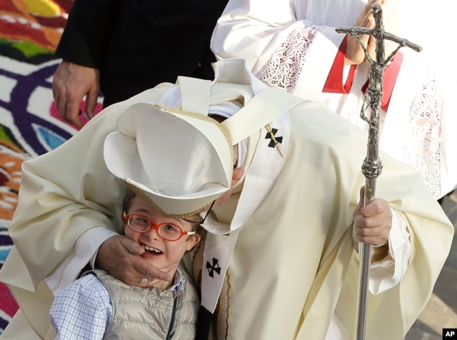 Pope Francis greets a child as he walks in procession at the Basilica of the Virgin of Guadalupe before celebrating Mass in Mexico City, Feb. 13, 2016.