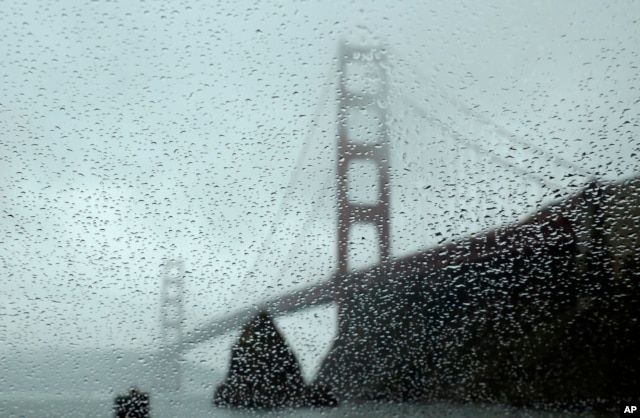 FILE - Rain drops bead on a car window below the Golden Gate Bridge, Jan. 5, 2016, in Sausalito, Calif. El Nino storms lined up in the Pacific, promising to drench parts of the West for more than two weeks.