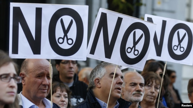Demonstrators hold banners during a protest by trade unions against cuts in public universities in Madrid, October 23, 2012.