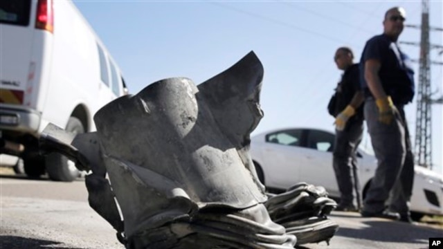 Israeli bomb technicians inspect the remains of a rocket fired from the Gaza Strip which landed near the southern city of Ashkelon on February 26, 2013.
