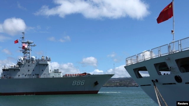 FILE - China’s replenishment ship, Qiandaohu, left, sails past its hospital ship, Peace Ark, as it docks in Honolulu, Hawaii. 