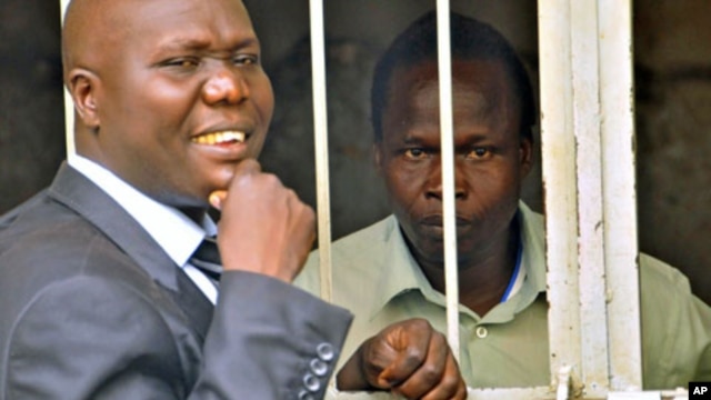Thomas Kwoyelo (R), a former director of field operations in the rebel group Lord's Resistance Army, talks to his lawyer, Caleb Alaka, after the court ordered he should be released, in Kampala, Uganda, November 2011. (file photo)