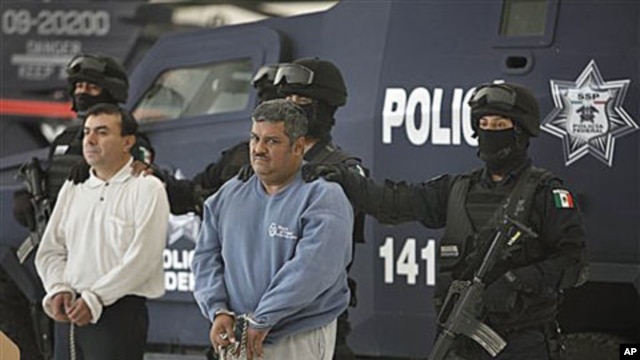 Eduardo Ramirez Valencia, alias 'El Profe,' center, and Ruben Barragan Monterrubi, alias 'El Montes,' are presented to the press at federal police headquarters in Mexico City, 02 Dec 2010