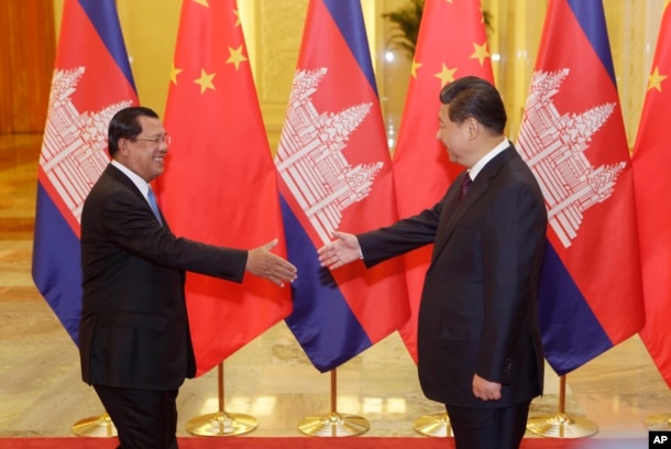FILE - Cambodian Prime Minister Hun Sen, left, shakes hands with China's President Xi Jinping before a meeting at the Great Hall of the People in Beijing Friday, Nov. 7, 2014.