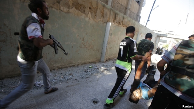 Free Syrian Army fighters carry the body of a fellow fighter after he was shot by a sniper at Seif a Dawla district in Syria's northwestern city of Aleppo September 4, 2012. 