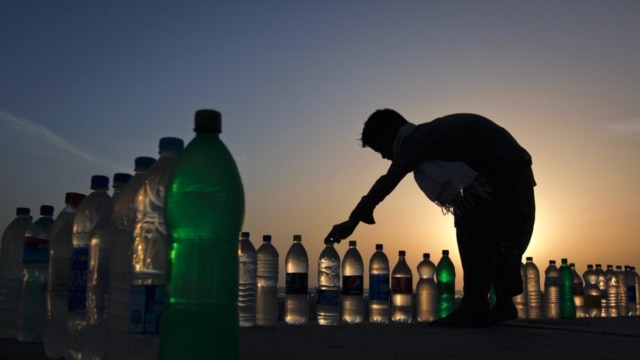 Un niño organiza botellas de agua potable para venderla en 10 rupias paquistanís, $ 0.11 centavos de dólar,  en la ciudad de Karachi.