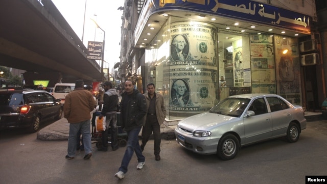 People walk past a foreign currency exchange center in Cairo (file photo).