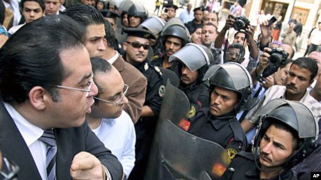 Egyptian opposition politician Ayman Nour (L) argues with anti-riot policemen blocking the road in front of his party headquarters, as dozens of protesters chant "freedom" and call for amending the constitution to allow fairer presidential elections, Cair