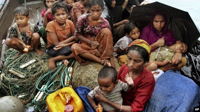In this June 13, 2012 file photo, Rohingya Muslims who fled Burma to Bangladesh to escape religious violence, sit in a boat after being intercepted crossing the Naf River by Bangladeshi border authorities in Taknaf, Bangladesh.