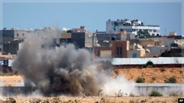 An explosion is seen near Muammar Gadhafi's main compound in the Bab al-Aziziya district in Tripoli, Libya, Tuesday, Aug. 23, 2011