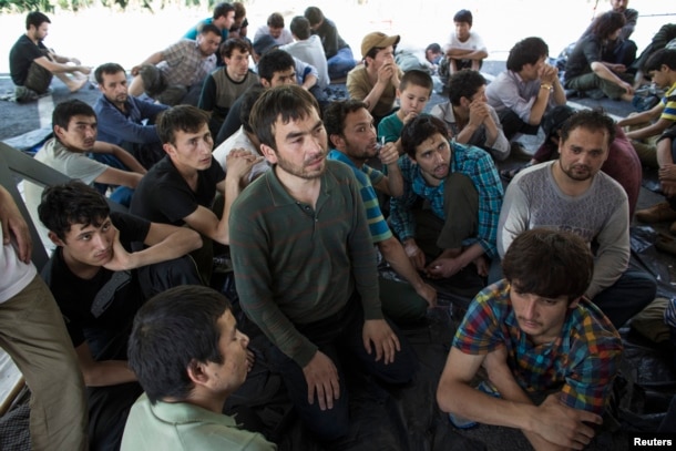 FILE - Suspected Uighurs from China's troubled far-western region of Xinjiang, sit inside a temporary shelter after they were detained at the immigration regional headquarters near the Thailand-Malaysia border in Hat Yai, Songkla, March 14, 2014.