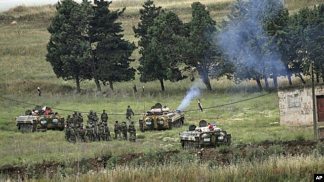 Syrian soldiers deploy in the village of Arida, as seen from the northern Lebanese village of Wadi Khaled near the Lebanese-Syrian border, May 20, 2011.