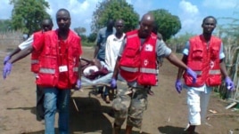 Des secouristes de la Croix-Rouge transportent un blessé après une attaque dans le Delta du Tana (21 déc. 2012)