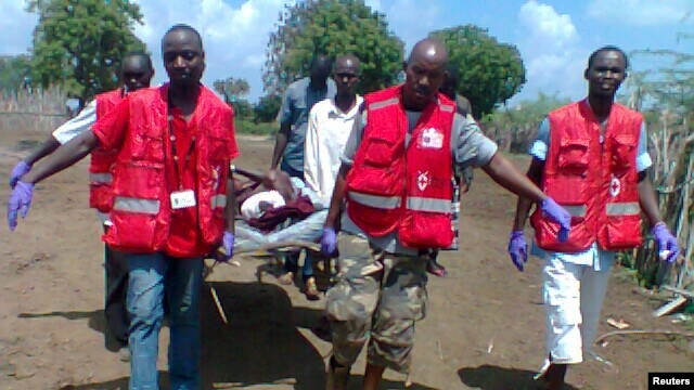 Des secouristes de la Croix-Rouge transportent un blessé après une attaque dans le Delta du Tana (21 déc. 2012)